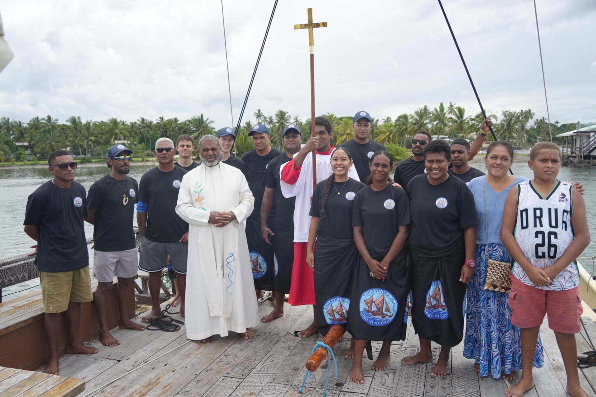 Sails of Hope participants and clergy aboard a traditional Pacific sailing vessel